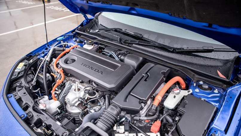 Le moteur de 1,8 litre de Toyota, l'unité de 2,0 litres de la Civic, sonne l'affaire, pénétrant dans l'habitacle avec un vrombissement agréable tout en assistant la configuration hybride électrique.  (Image : Tom White)